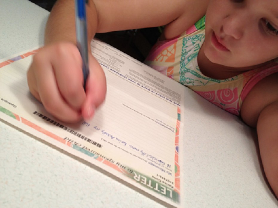 Young girl writing a letter.