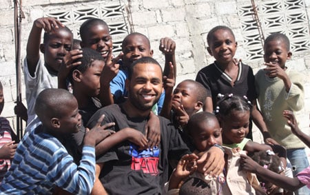 group of children surrounding young man