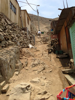 young man walking up hillside between homes