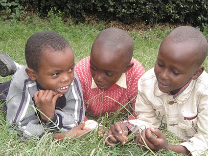 three boys laying in the grass