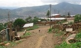 dirt road on hillside with a few buildings