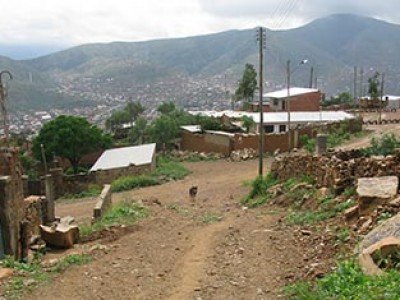 dirt road on hillside with a few buildings
