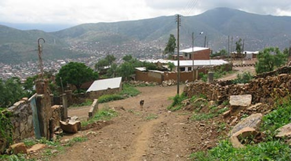dirt road on hillside with a few buildings