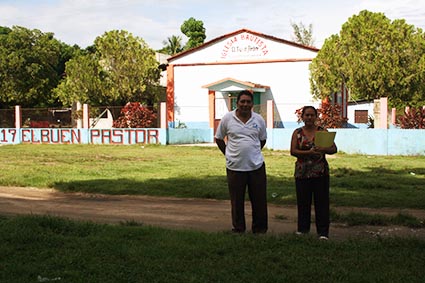 Two people stand in front of a church