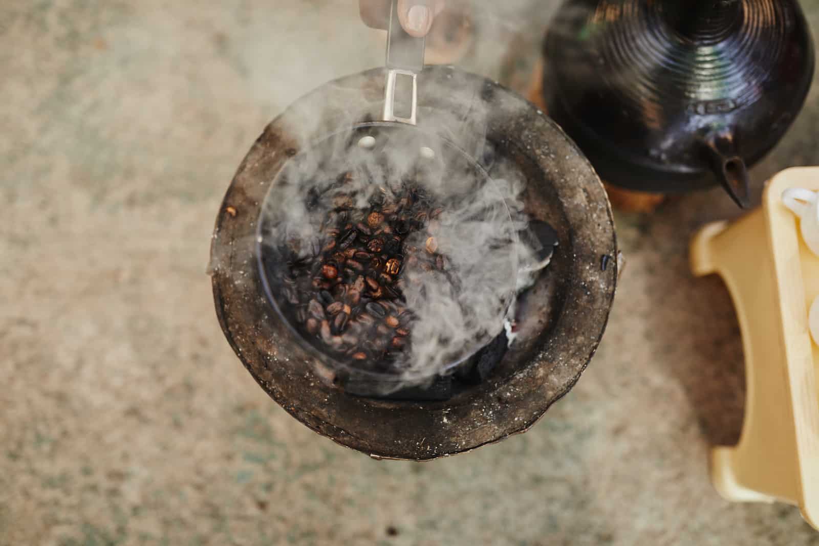 Coffee Beans roast and smoke over a fire.