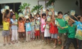 a group of children holding up bibles