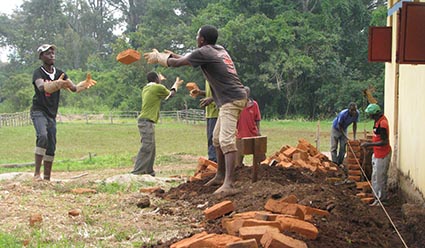 Men tossing bricks to one another