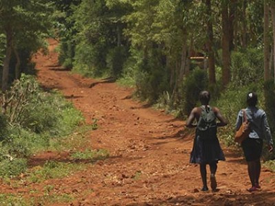 two girls walking down a dirt road