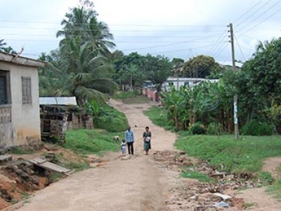 family walking along dirt road in a village