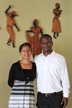 man and woman standing in front of local art on the wall