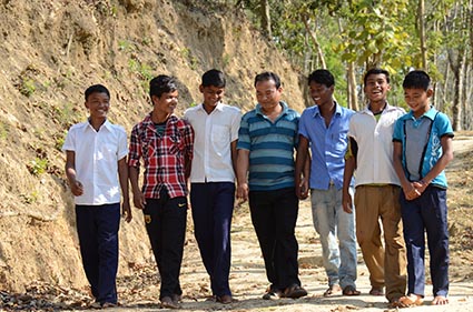 man with group of male youth walking on a road