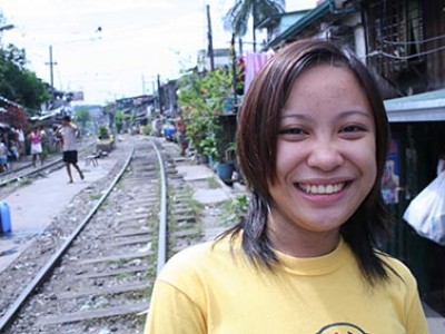 smiling young lady near railroad tracks