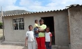 woman with children standing outside house