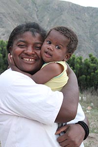 smiling woman hugging a small child