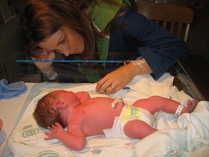 woman looking at newborn baby