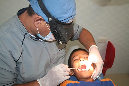Young boy in Columbia having his teeth checked by a dentist