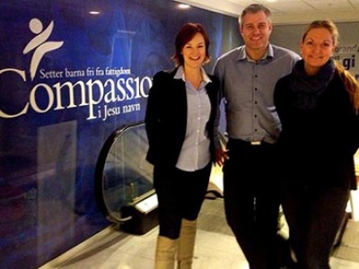 Three Compassion Staff of Scandinavia standing in front of a Compassion branded wall