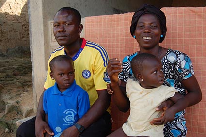 man and woman sitting with two small children