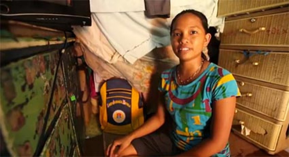 a girl sitting next to a dresser by a yellow backpack