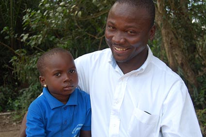 smiling man in white shirt sitting with serious looking boy