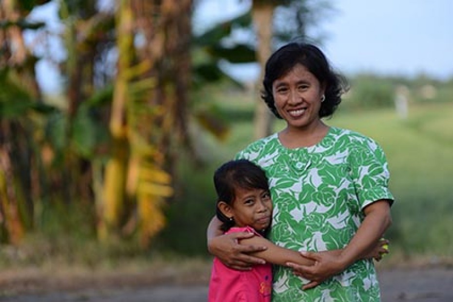 Small child and lady standing outside.