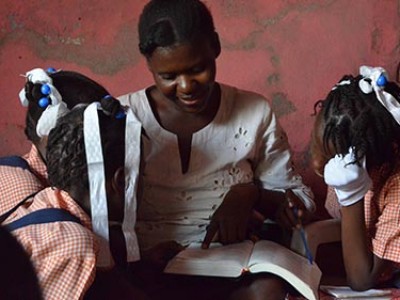 woman reading a book to children