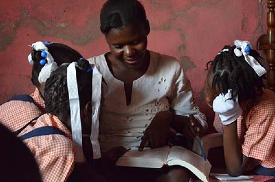 woman reading a book to children