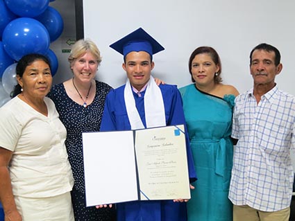 Adults posing with someone in a cap and gown