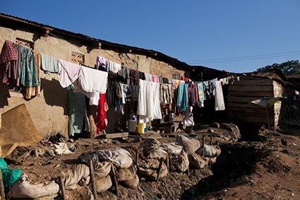 Laundry hung out to dry near dirt and trash in a slum