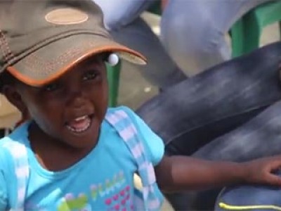 child wearing blue shirt and baseball cap