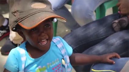 child wearing blue shirt and baseball cap