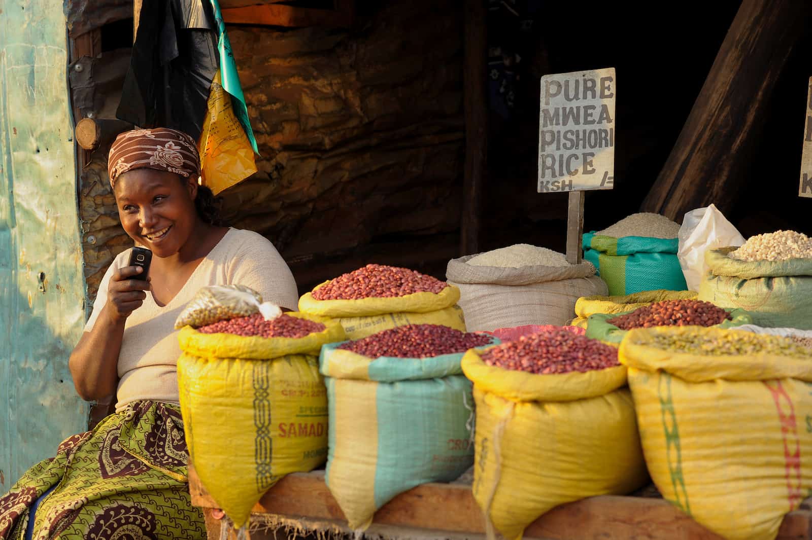 A woman selling beans on a street in Kibera, where some people go for poverty tourism.