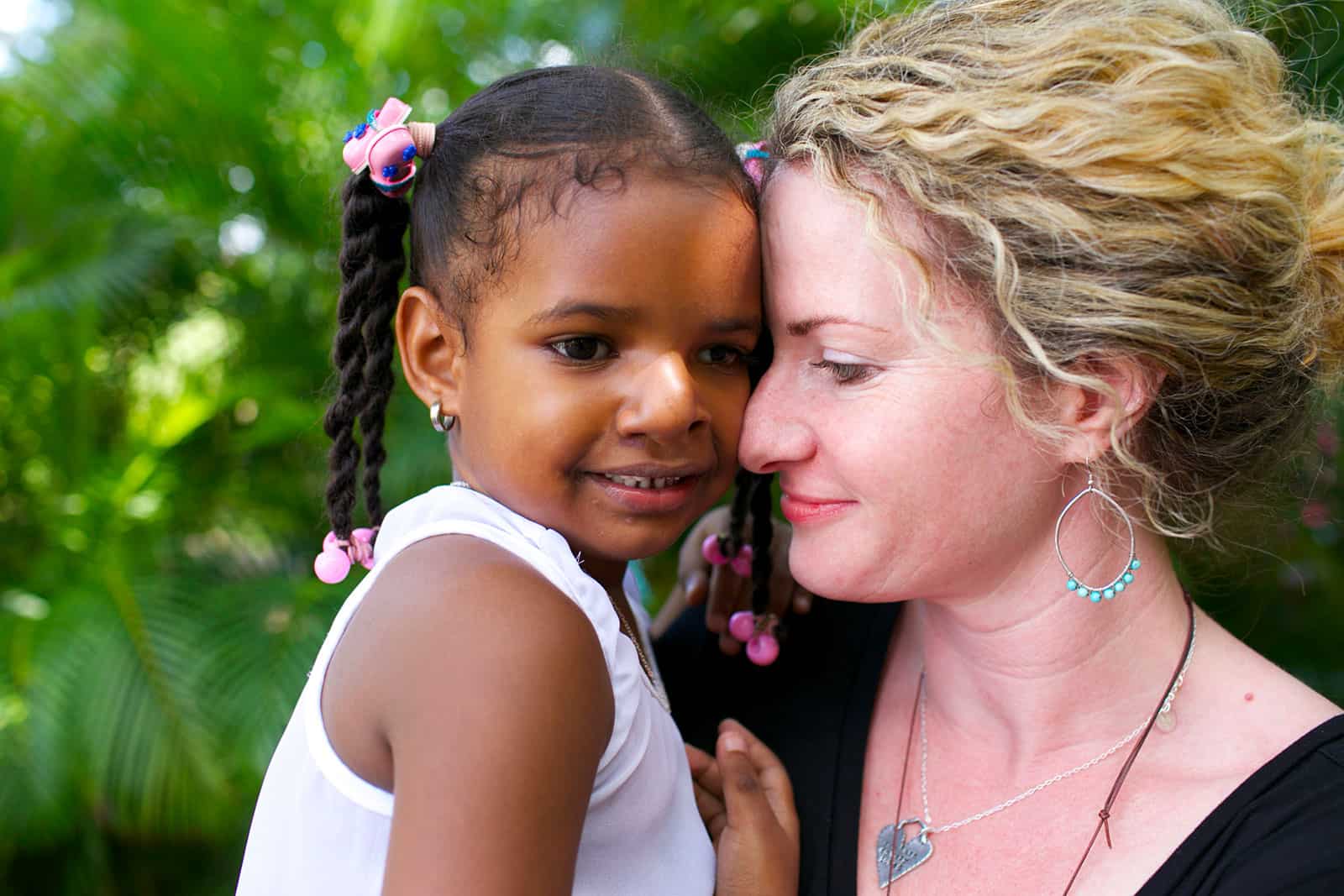 A woman holds a young girl in her arms