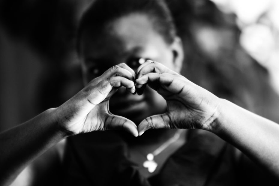 A child makes the shape of a heart with their hands