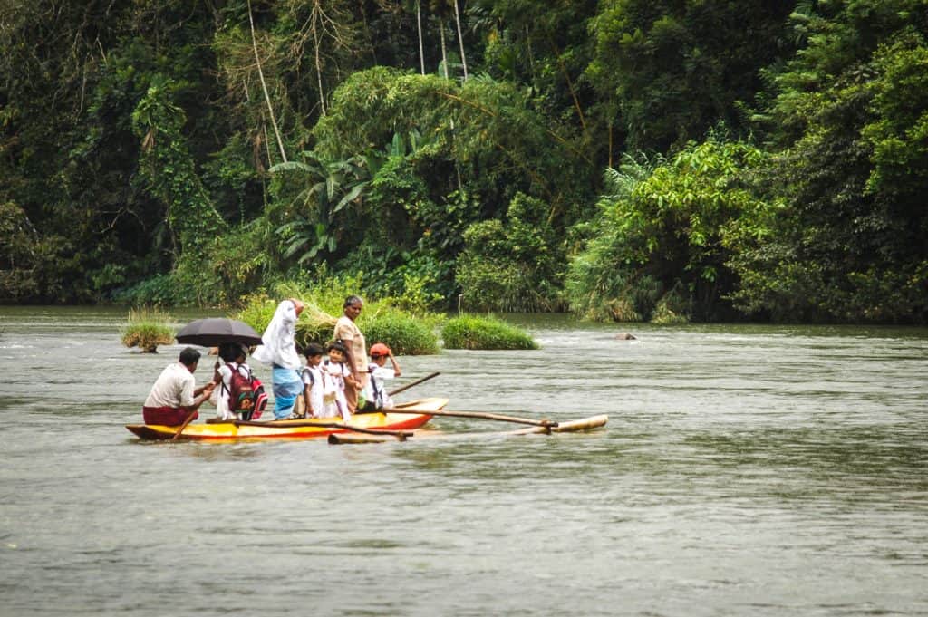 Adults and children ride in a yello boat in Sri Lanka