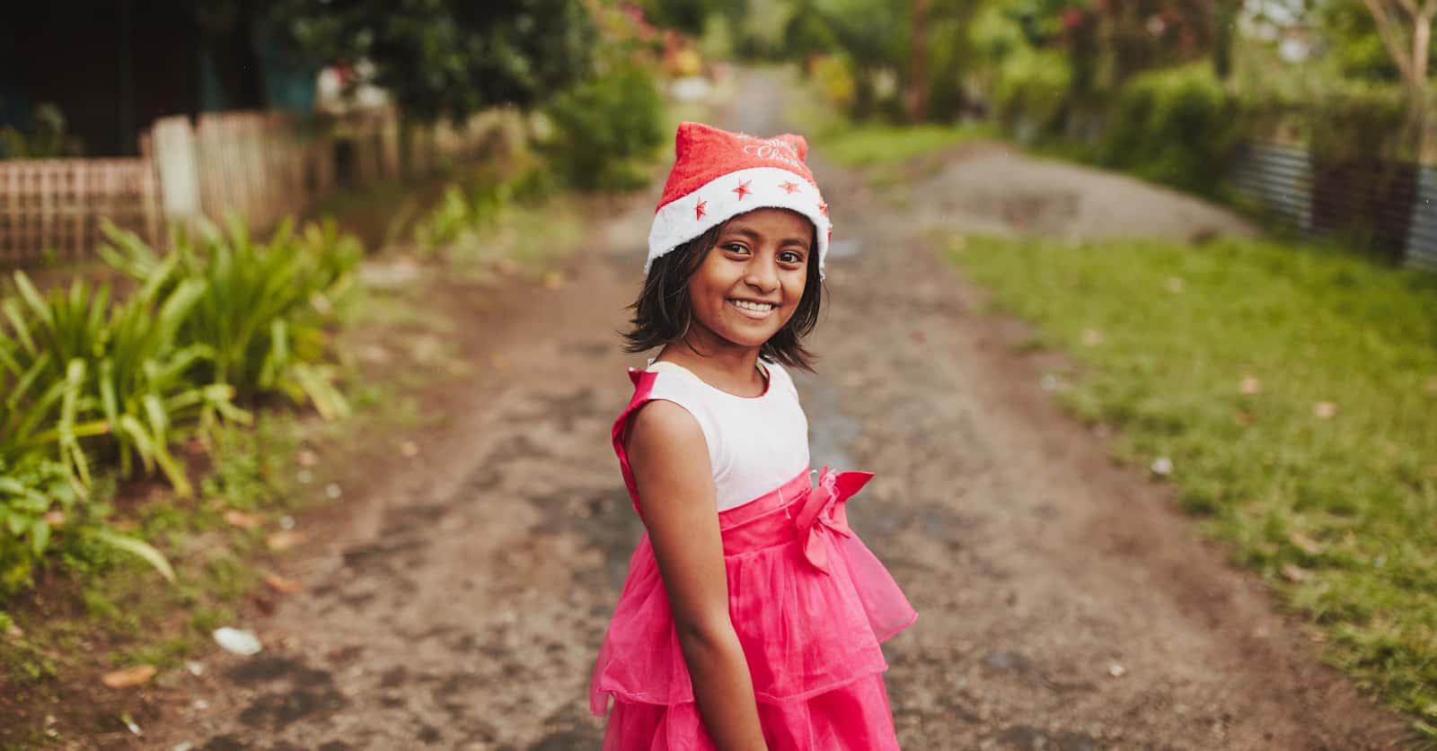 Girl wearing a red dress and Santa hat in Indonesia.