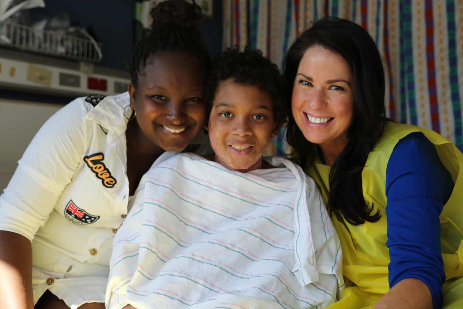 two women sitting with boy in hospital