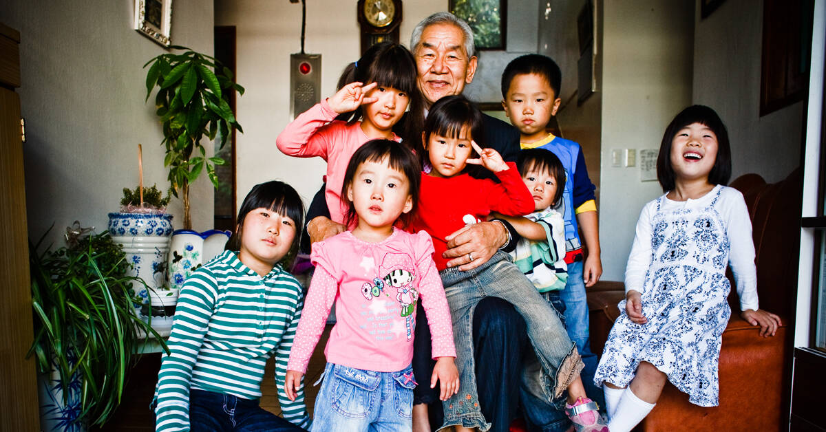 older gentleman surrounded by seven children