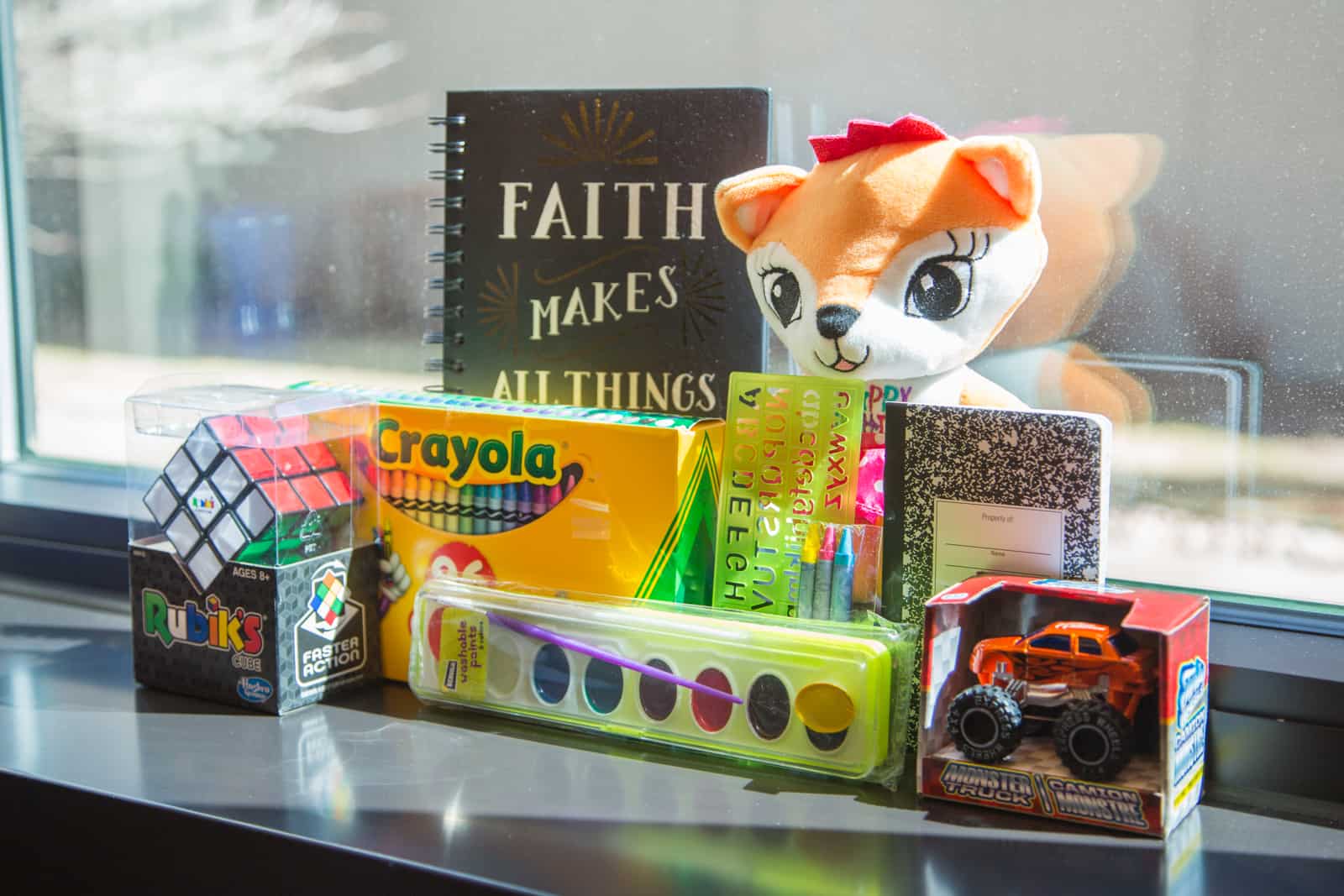 How Long Does It Take for My Letters to Be Delivered? Items sitting on a windowsill, including a stuffed fox, paint set, Rubix cube, crayons and toy car