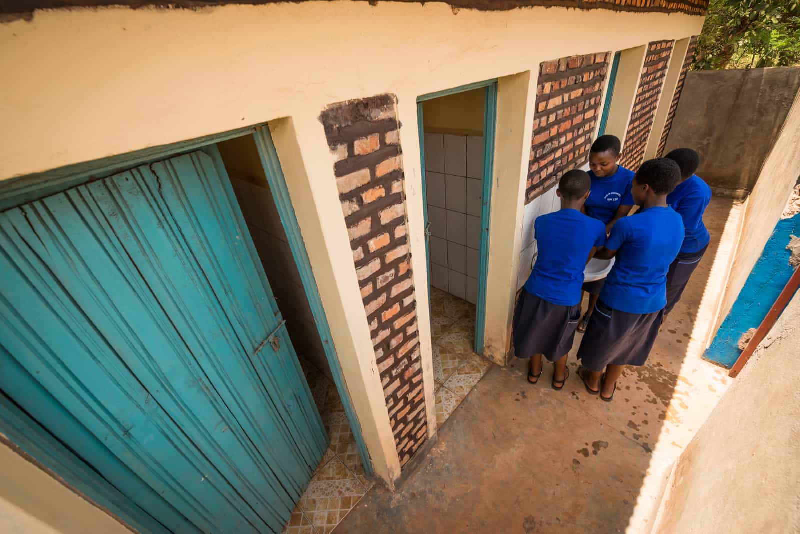Girls in Rwanda gather around a sink to wash their hands