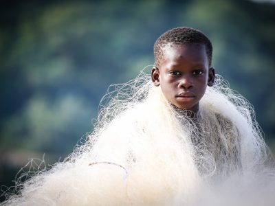 A boy with a net wrapped around his shoulders