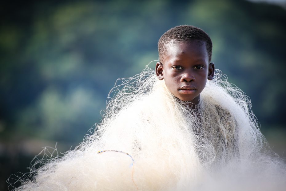 A boy with a net wrapped around his shoulders