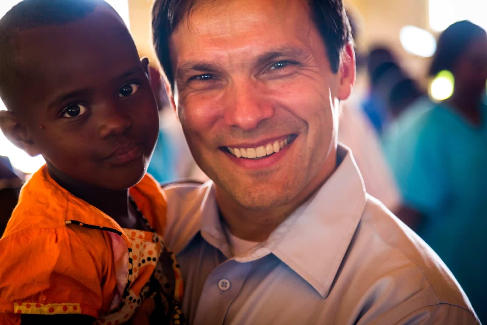 An Easter Message of hope form our President, pictured smiling and holding a young Rwandan girl wearing an orange dress. 