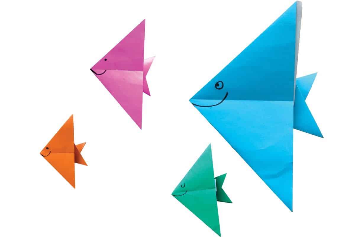 Four origami fishes in blue, green, orange and pink paper.