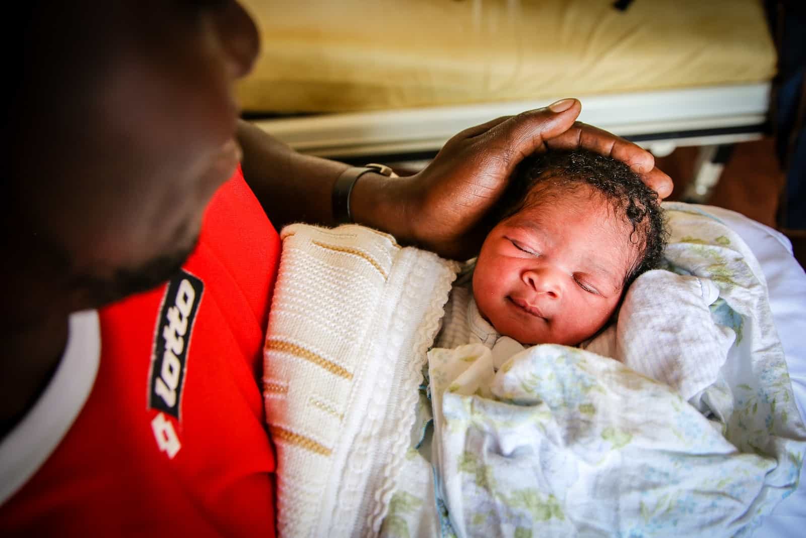 A man holds a cute newborn baby.