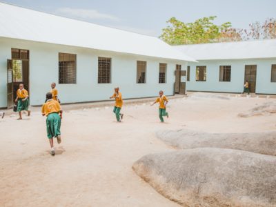 Students run and play in a courtyard ringed by classrooms.