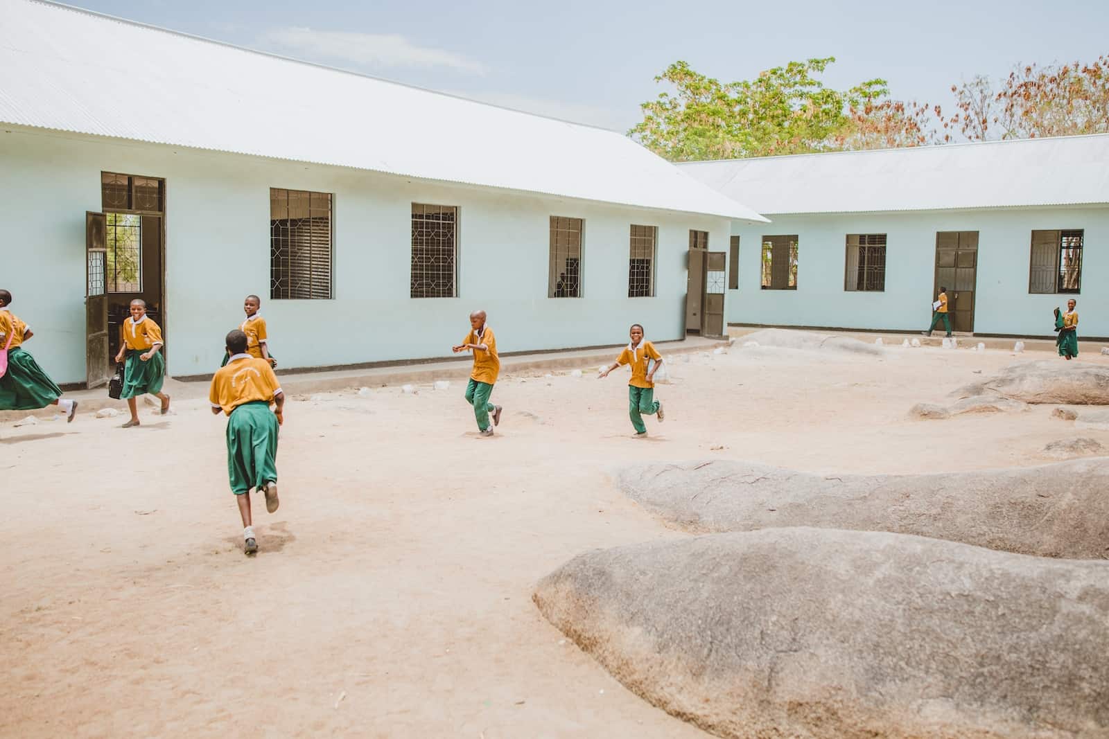 Students run and play in a courtyard ringed by classrooms. 