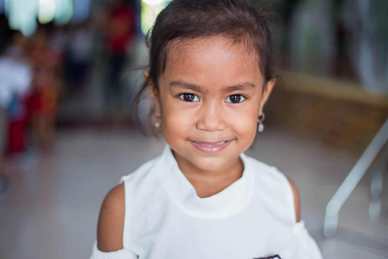 Convention on the Rights of the Child: A girl in a white shirt smiles at the camera. 