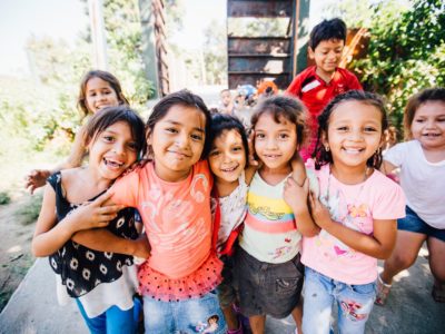 A group of children in Honduras smile for the camera.