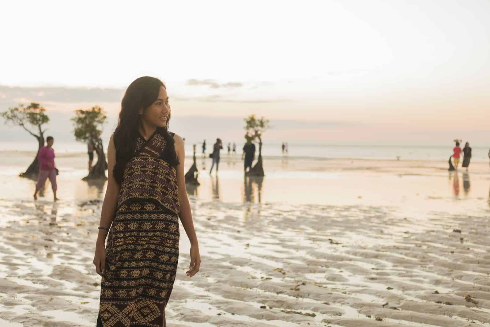 A girl on the beach wearing traditional Indonesian clothes.